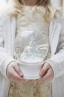 Cropped shot of young girl holding christmas snow globe — Stock Photo