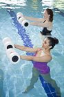Mulheres se exercitando na piscina interior — Fotografia de Stock