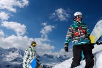 Snowboarders en la cima de la montaña nevada - foto de stock