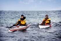 Два человека плывут на байдарках по морю — стоковое фото