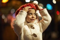Young girl, outdoors at night, wearing coat and red beret — Stock Photo