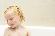Junge spielt mit Wasser in Badewanne — Stockfoto