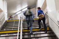 Couple climbing subway steps — Stock Photo