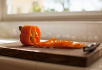 Red pepper slices on chopping board — Stock Photo