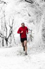 Man running through woods in winter, Wenlock Edge, Shropshire, Inghilterra, Regno Unito — Foto stock