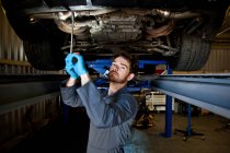 Mechaniker macht Wartung unter Auto — Stockfoto