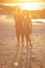 Casal andando descalço na praia — Fotografia de Stock