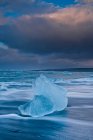 Айсберг на пляжі і бурхливе небо — стокове фото