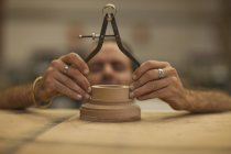 Close up of carpenter measuring turning wood in workshop — Stock Photo