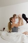 Mother holding baby boy up in mid air — Stock Photo