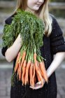 Gros plan de la fille avec un tas de carottes — Photo de stock