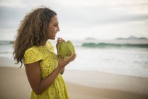 Junge Frau trinkt Kokosmilch am Strand von Ipanema, Rio de Janeiro, Brasilien — Stockfoto