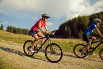 Junge Frau und Mann Mountainbiken, Steiermark, Österreich — Stockfoto