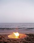 Bonfire burning on beach — Stock Photo