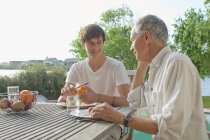 Father and son eating fruits outdoors — Stock Photo