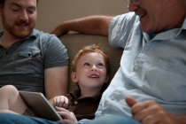 Garçon montrant tablette numérique à grand-père — Photo de stock