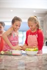 Adolescentes niñas exprimiendo limones en la cocina - foto de stock
