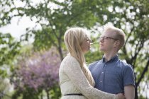 Young couple embracing in park — Stock Photo