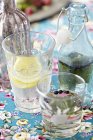 Close-up view of bottles and glasses of homemade lemonade — Stock Photo