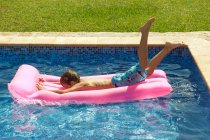 Um menino que mergulha em um inflável — Fotografia de Stock