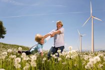 Pai e filho com turbinas eólicas no fundo — Fotografia de Stock
