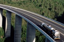 Oil tanker on elevated motorway with green forest on background — Stock Photo