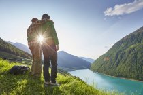 Young couple looking out over Vernagt reservoir and Finailhof farmhouse, Val Senales, South Tyrol, Italy — Stock Photo