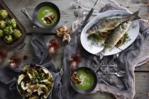 Nature morte avec poisson branzino et soupe — Photo de stock