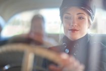Frau spielt Chauffeur in Oldtimer — Stockfoto