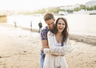 Молода пара обіймається річкою — стокове фото