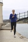 Mature woman exercising, running, outdoors — Stock Photo