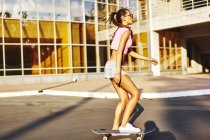 Femme skateboard sur une journée ensoleillée — Photo de stock