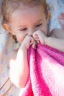 Portrait of young girl holding pink towel — Stock Photo