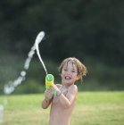 Мальчик веселится с водяным пистолетом — стоковое фото