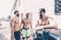 Drei männliche Crosstrainer plaudern vor dem Fitnessstudio — Stockfoto