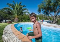 Rapaz a sair da piscina exterior — Fotografia de Stock