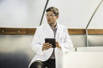 Scientist using digital tablet in plant growth research centre poly tunnel — Stock Photo