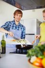 Couple frying vegetables together — Stock Photo