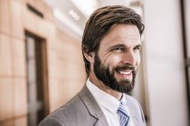 Бородатий бізнесмен дивиться геть усміхнений — стокове фото