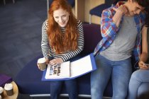 Молода студентка коледжу з виносним файлом читання кави в загальній кімнаті — стокове фото
