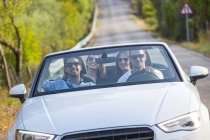 Four adult friends driving on rural road in convertible, Majorca, Spain — Stock Photo