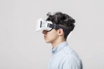 Homem jovem vestindo fone de ouvido de realidade virtual — Fotografia de Stock
