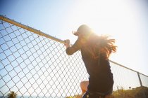 Молода жінка бурмоче на дротяному паркані — стокове фото