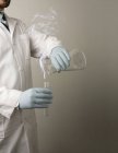 Scienziato che sperimenta sostanze chimiche liquide e provetta, colpo ritagliato — Foto stock