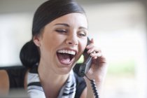 Junge Büroangestellte telefoniert auf Festnetztelefon — Stockfoto