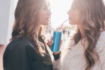 Sœurs jumelles, en plein air, canette de boisson gazeuse à la paille — Photo de stock