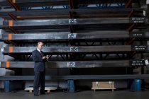 Бізнесмен на мобільному телефоні на металевому заводі — стокове фото