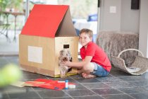 Niño construyendo perrera para su perro - foto de stock