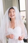Молода жінка в весільній сукні і сміється — стокове фото