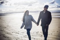 Young couple holding hands, Brean Sands, Somerset, England — Stock Photo